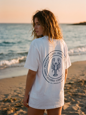 Lobster Stamp tee worn at golden hour on a Mediterranean beach